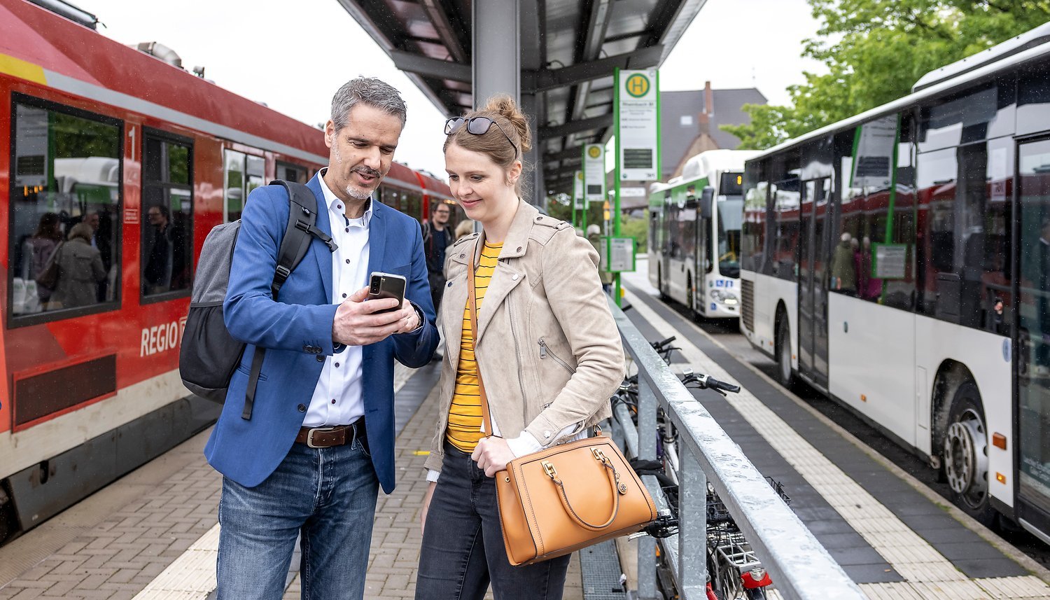 Pärchen an Bahnhalt mit Busanschluss