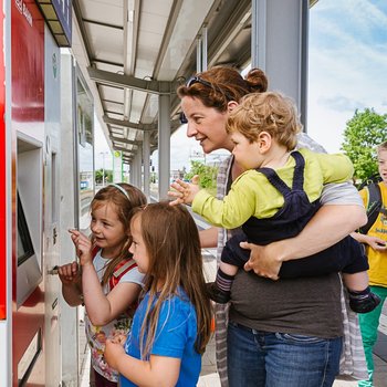 [Translate to Englisch:] Mutter mit Kindern am Ticketautomaten
